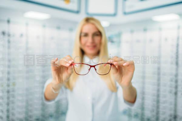 女性眼镜师在光学商店展示眼镜
