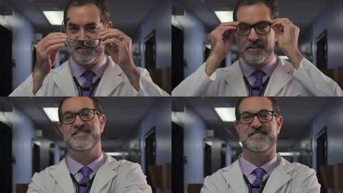 一位男医生戴上眼镜,微笑着